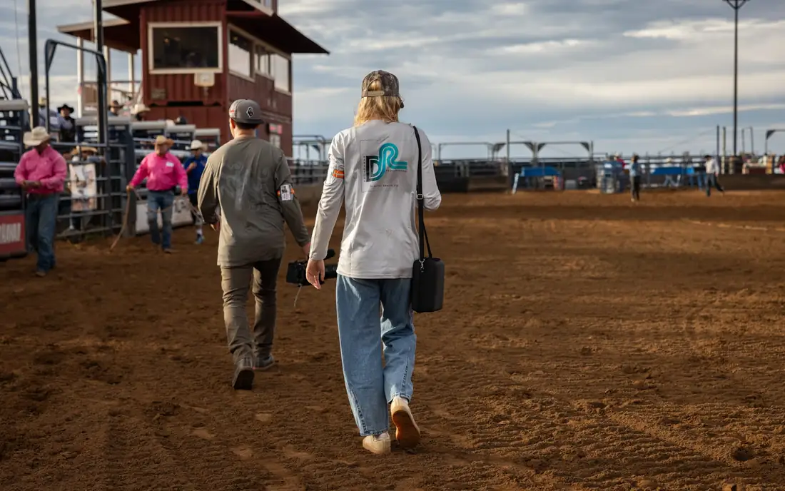 Digital Reach team members crossing the arena at a Maui rodeo shoot