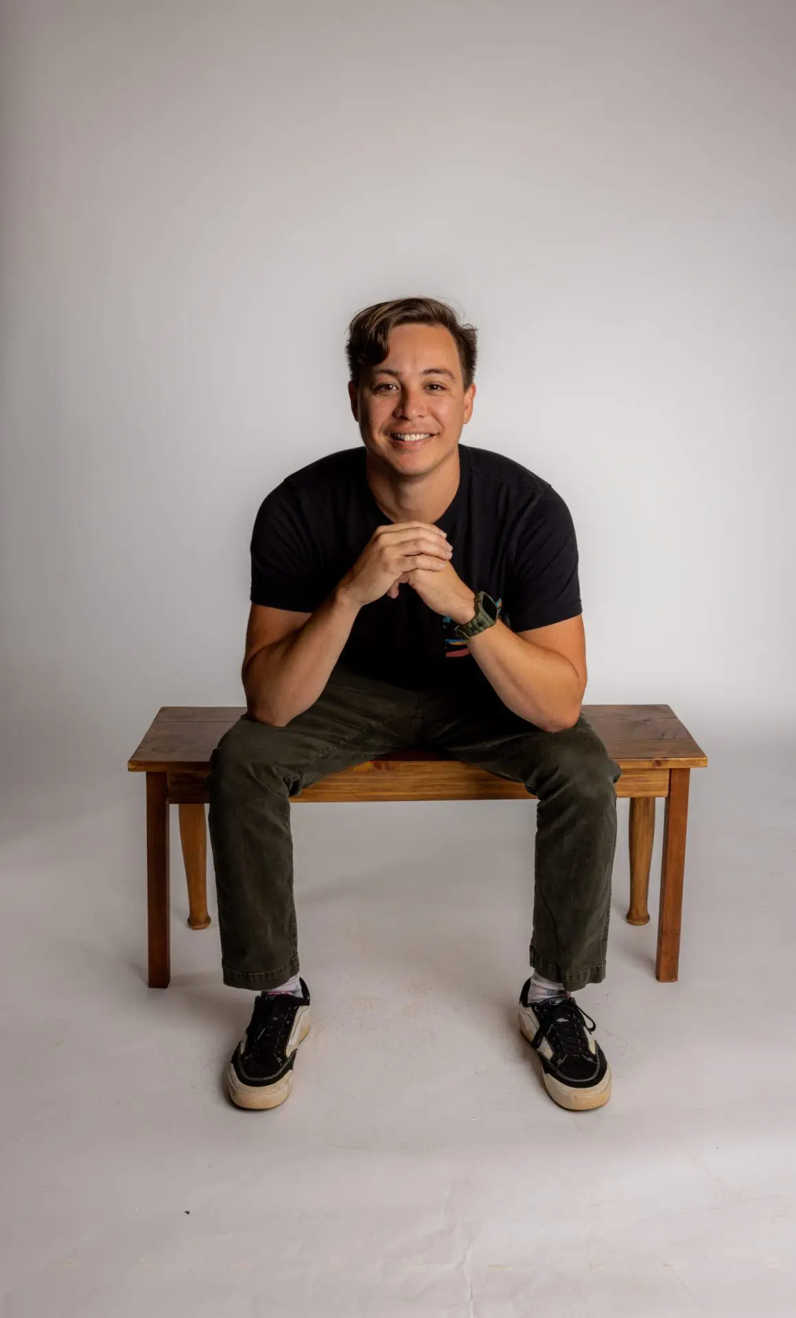 Digital Reach, Smiling member of the Digital Reach team sitting on a wooden bench.