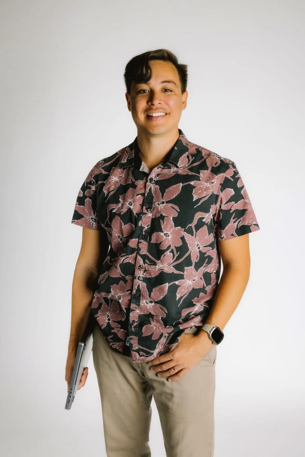Digital Reach, Smiling man in floral shirt holding laptop